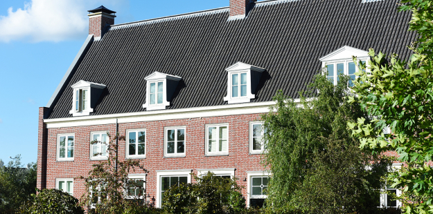Detailbeeld van een gevel van een woning waar je de raampartijen goed ziet